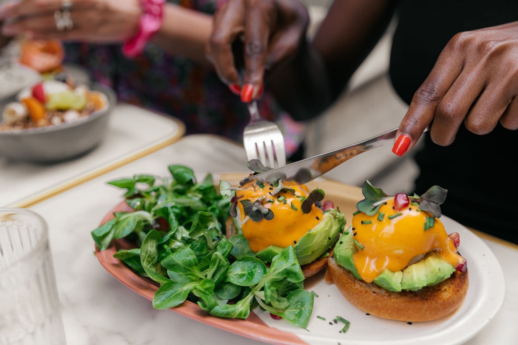 Bun benedict avec œufs pochés coulants, avocat et jeunes pousses