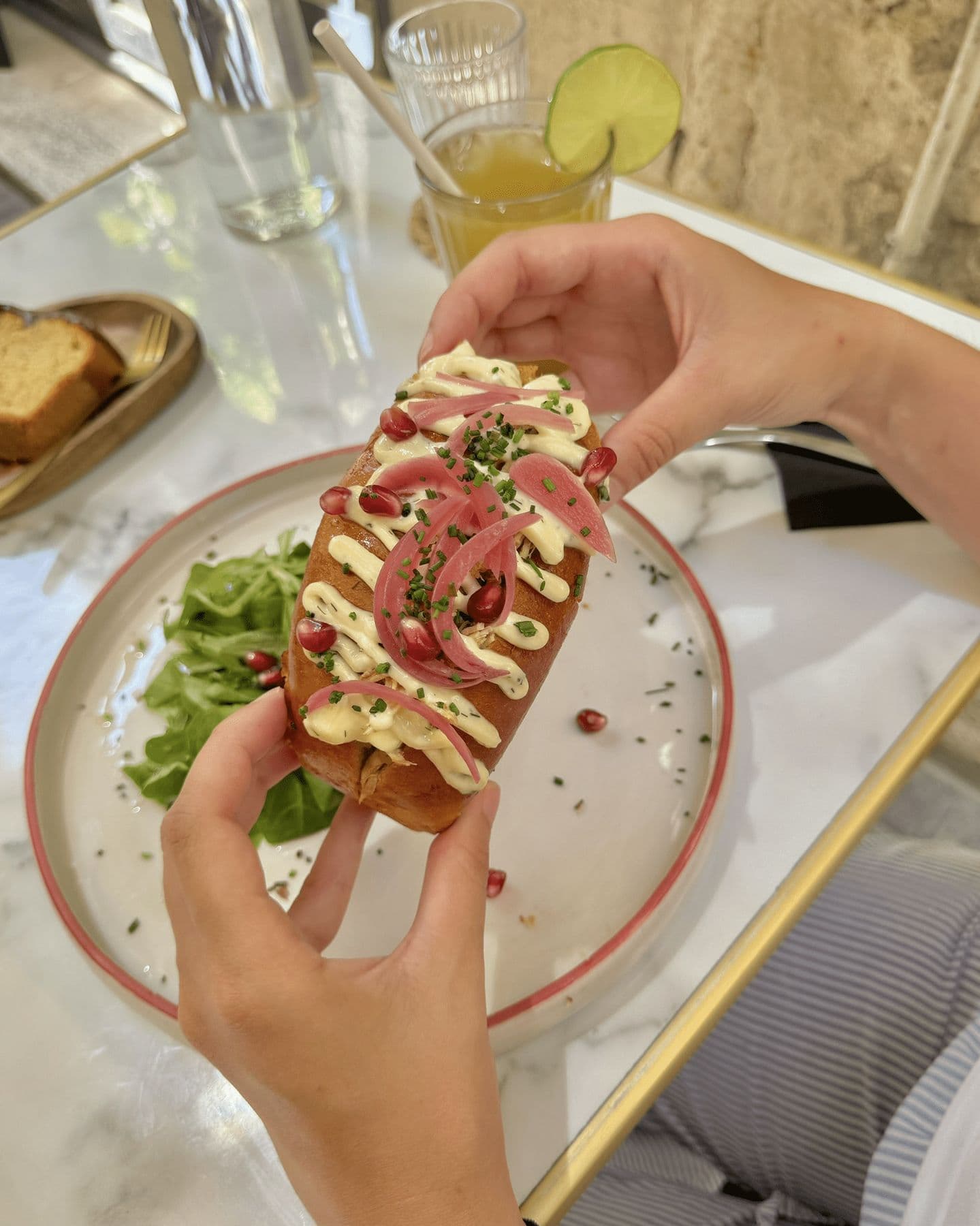 Chicken roll servi à table, pain brioché garni de poulet effiloché et de pickles d'oignons rouges
