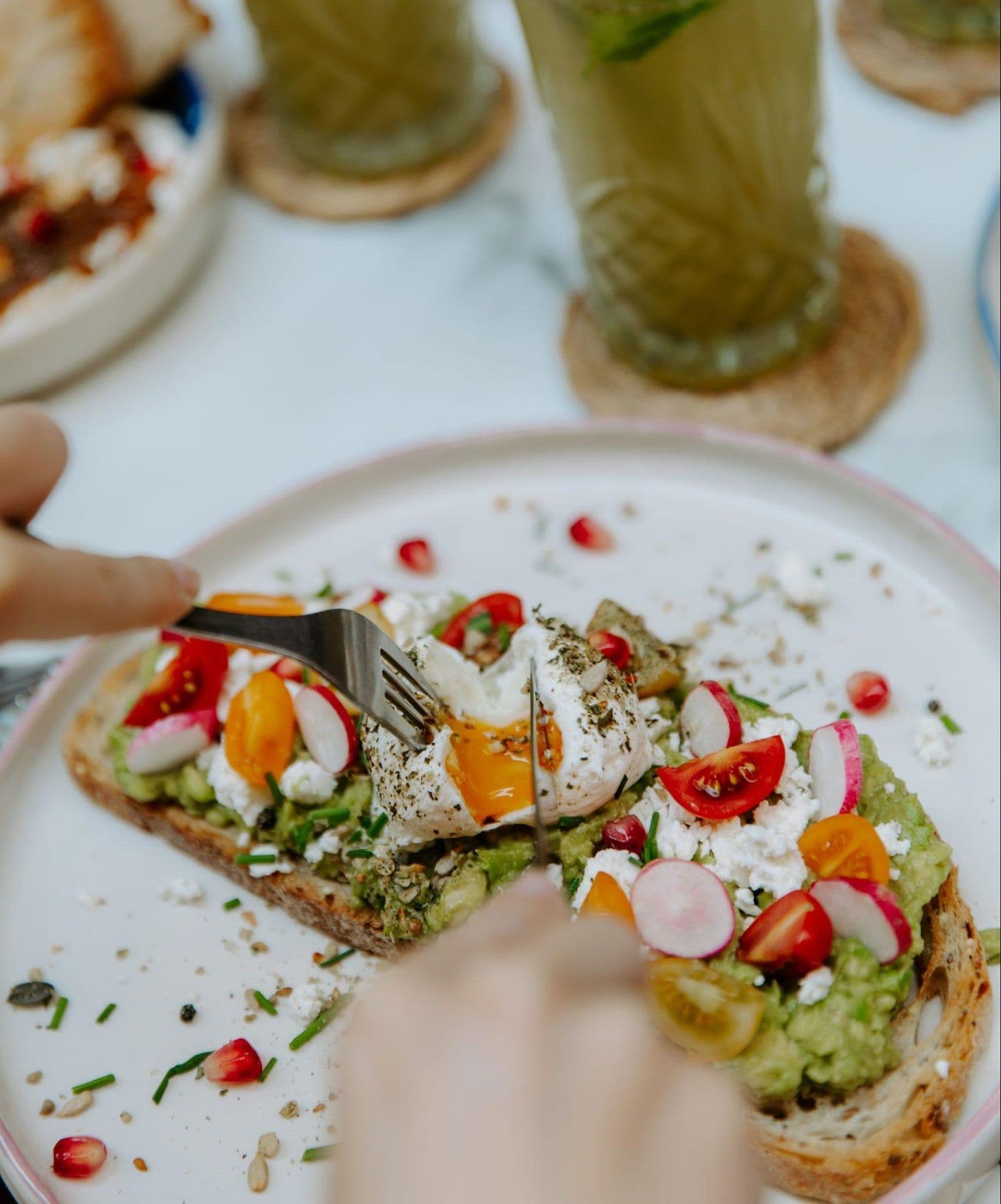 Toast à l'avocat garni d'un œuf poché, de feta et de tomates cerises